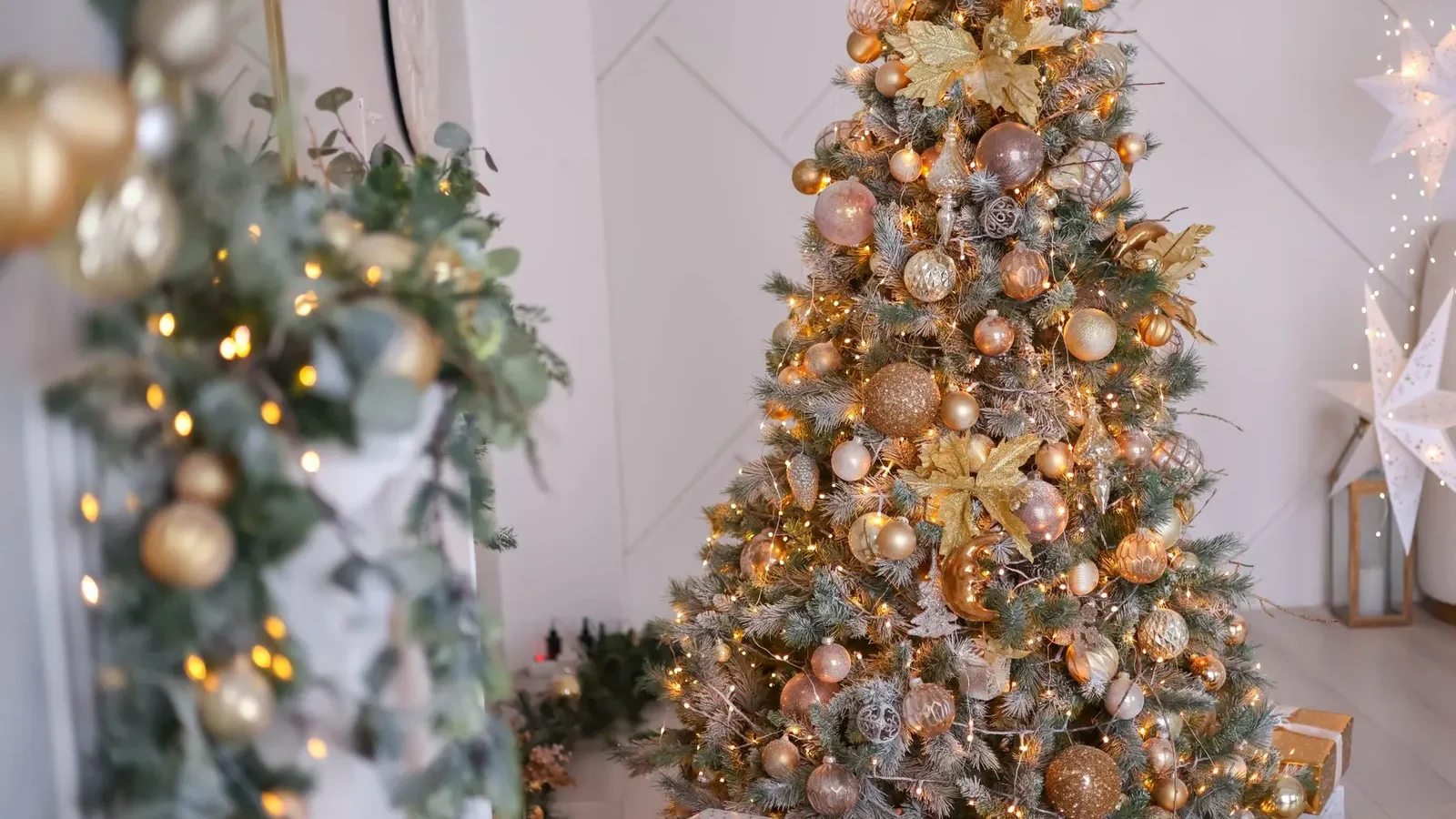 A Christmas tree decorated with lights and baubles in a living room